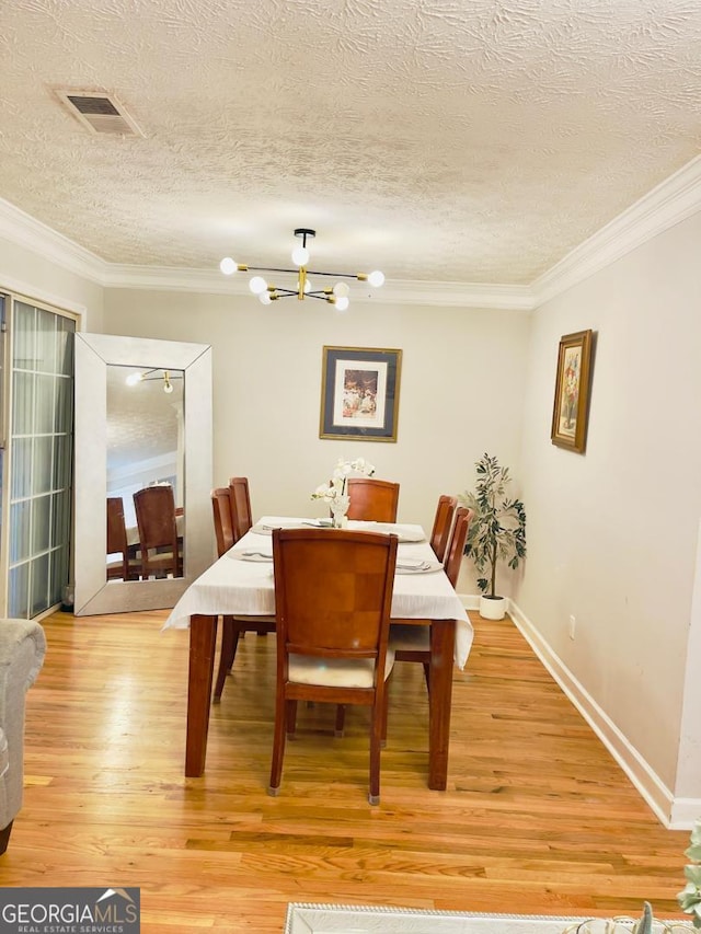 6594 Meadow Green Cir, Peachtree Corners, GA 30092 - dining room featuring ornamental molding, a chandelier, a textured ceiling, light wood-style flooring, and baseboards