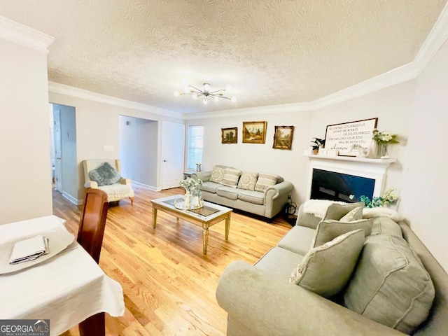6594 Meadow Green Cir, Peachtree Corners, GA 30092 - living area featuring crown molding, light wood-style floors, a textured ceiling, a fireplace, and a chandelier