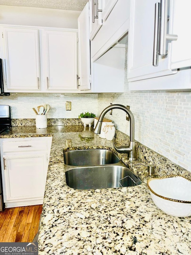 6594 Meadow Green Cir, Peachtree Corners, GA 30092 - kitchen featuring a sink, stove, white cabinetry, backsplash, and light stone counters