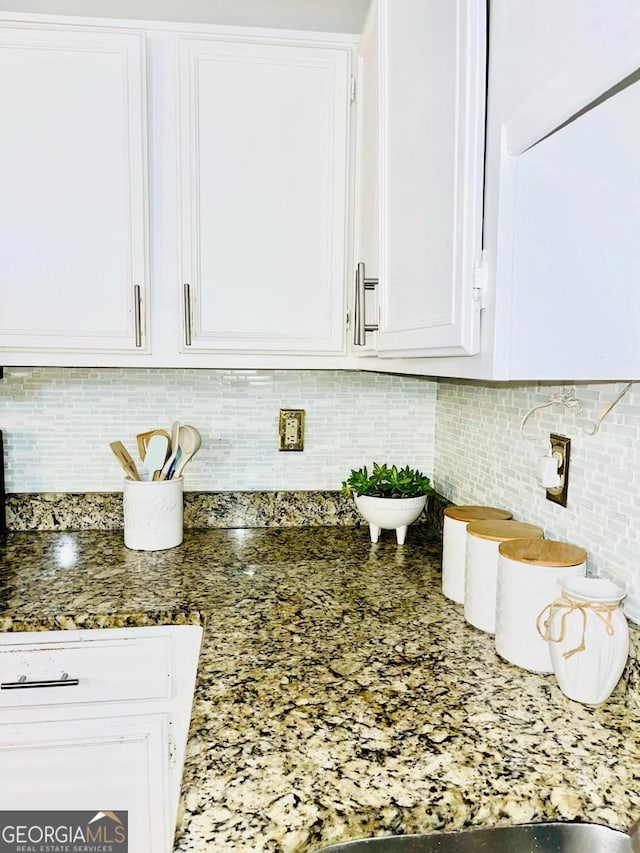 6594 Meadow Green Cir, Peachtree Corners, GA 30092 - kitchen view of white cabinets, tasteful backsplash, and dark stone countertops