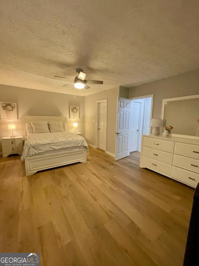 6594 Meadow Green Cir, Peachtree Corners, GA 30092 - bedroom with wood finished floors, a textured ceiling, a ceiling fan, and baseboards