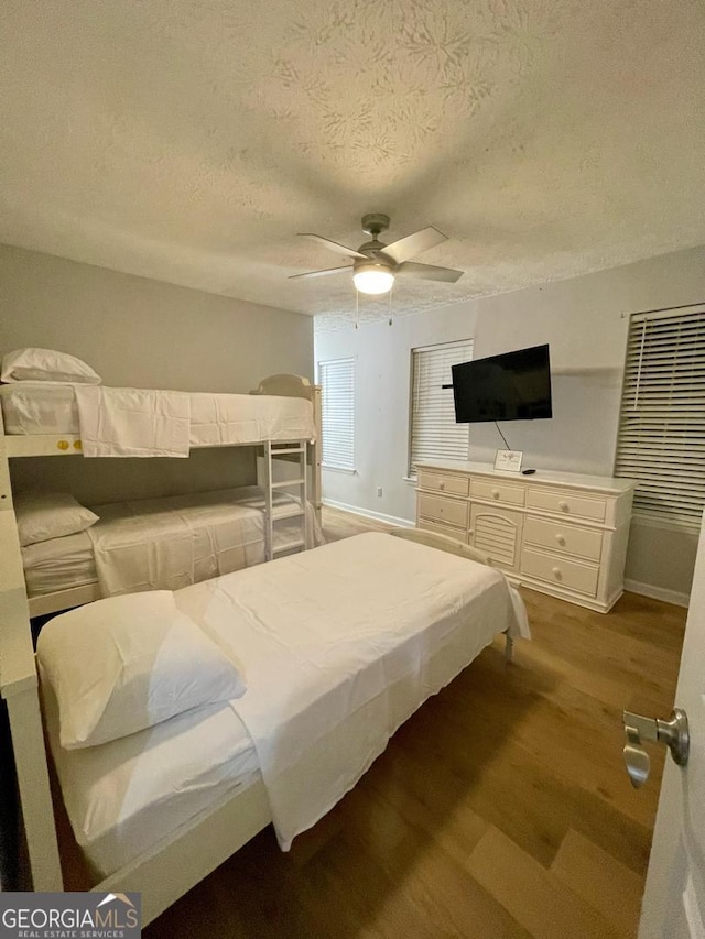 6594 Meadow Green Cir, Peachtree Corners, GA 30092 - bedroom with wood finished floors, a textured ceiling, a ceiling fan, and baseboards