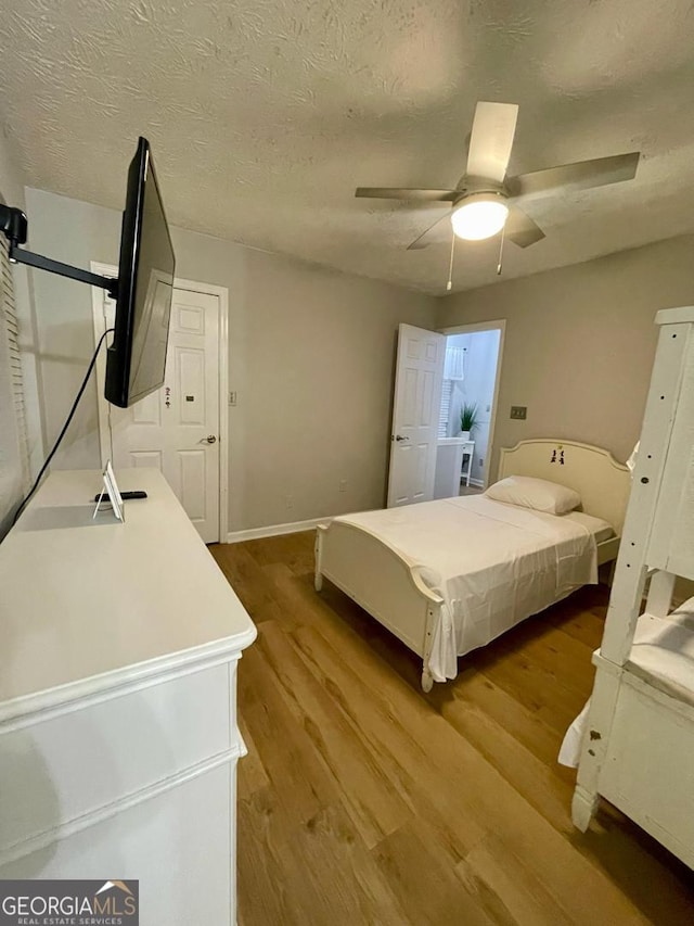 6594 Meadow Green Cir, Peachtree Corners, GA 30092 - bedroom featuring wood finished floors, baseboards, a ceiling fan, and a textured ceiling