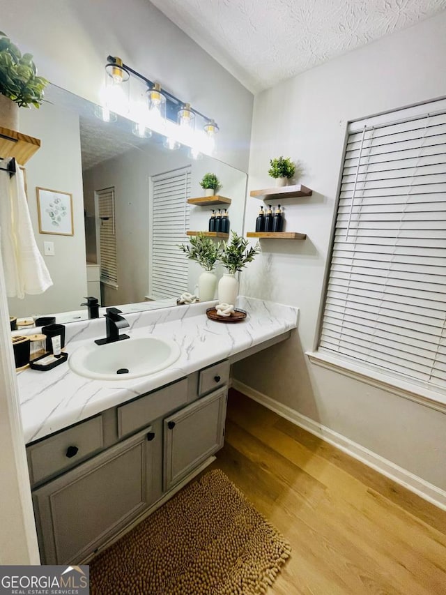 6594 Meadow Green Cir, Peachtree Corners, GA 30092 - bathroom featuring wood finished floors, vanity, baseboards, and a textured ceiling