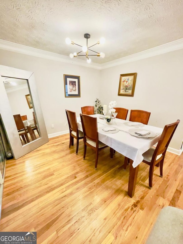 6594 Meadow Green Cir, Peachtree Corners, GA 30092 - dining space featuring light wood-type flooring, a chandelier, crown molding, baseboards, and a textured ceiling
