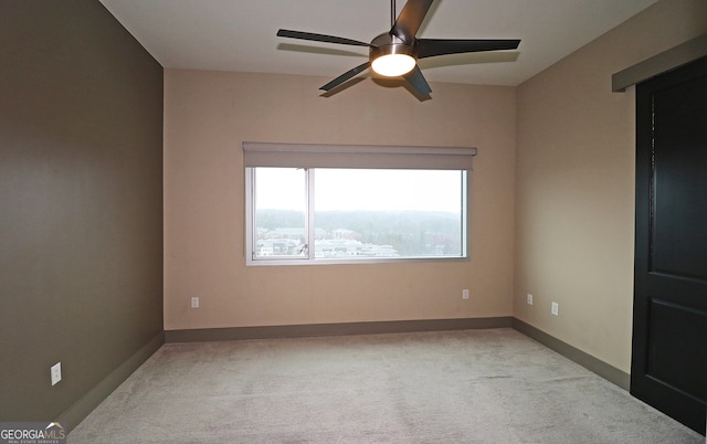 carpeted spare room featuring ceiling fan