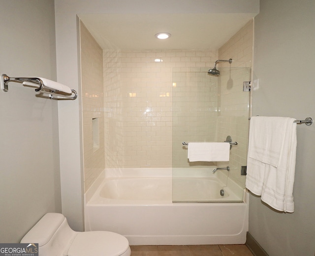 bathroom with tiled shower / bath, tile patterned floors, and toilet