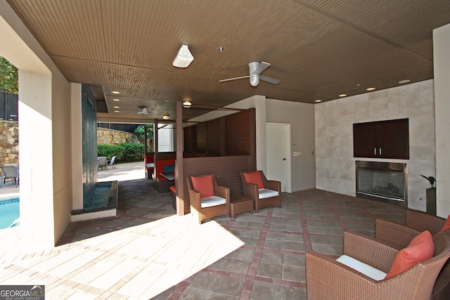 view of patio / terrace featuring ceiling fan and a fireplace