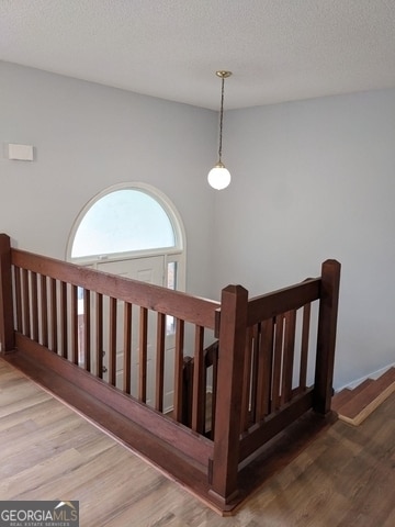 stairway featuring hardwood / wood-style flooring and a textured ceiling