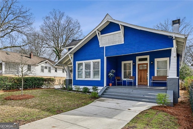 view of front of property featuring covered porch and a front lawn