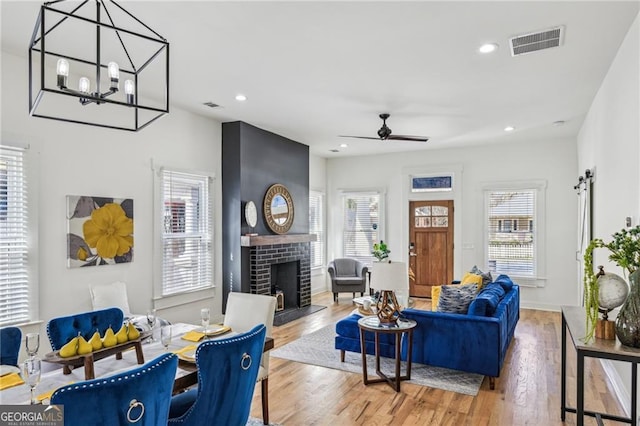 living room with ceiling fan, a wealth of natural light, and light wood-type flooring