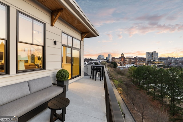 balcony at dusk featuring a city view