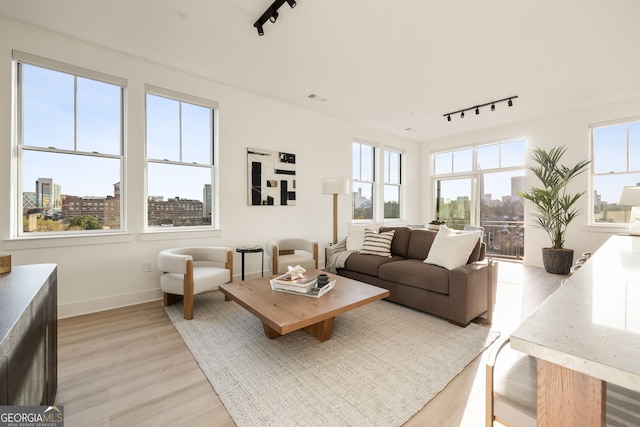living area featuring light wood-style floors, a view of city, and a healthy amount of sunlight