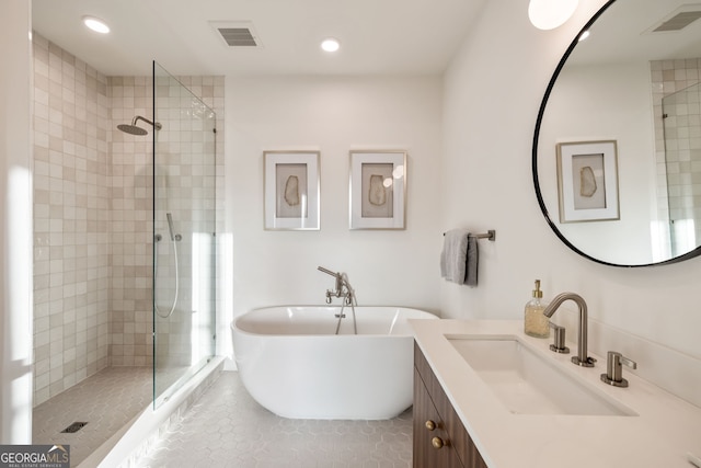 bathroom featuring a soaking tub, visible vents, and a tile shower
