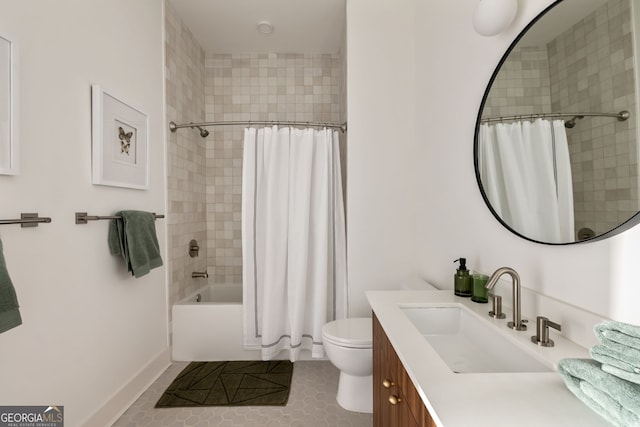 bathroom featuring toilet, shower / bath combo with shower curtain, vanity, baseboards, and tile patterned floors