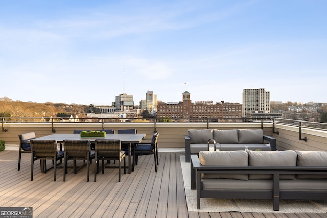 wooden deck with outdoor dining area, outdoor lounge area, and a city view