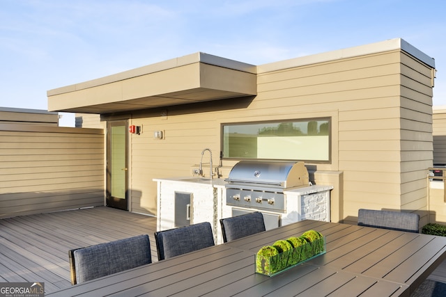 wooden terrace featuring outdoor dining area, area for grilling, a sink, and a grill