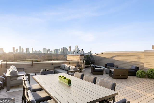 deck with a view of city, outdoor dining space, and an outdoor hangout area