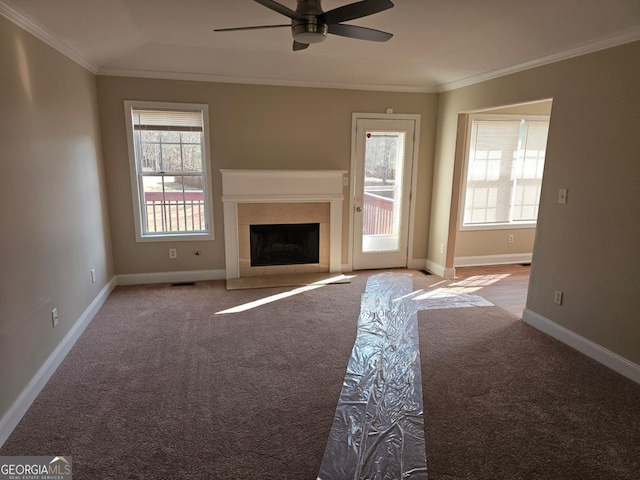 unfurnished living room with ornamental molding, carpet, and ceiling fan