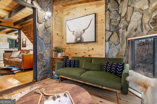 living area featuring beamed ceiling, wood ceiling, wood walls, and hardwood / wood-style floors