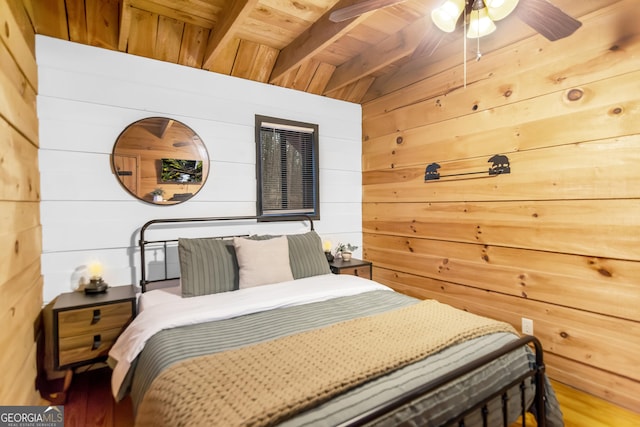 bedroom with wooden walls, beamed ceiling, and wooden ceiling