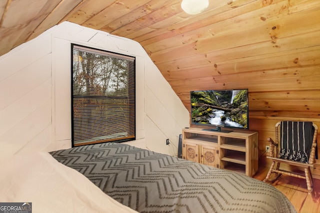 bedroom with wood-type flooring, lofted ceiling, wooden walls, and wood ceiling