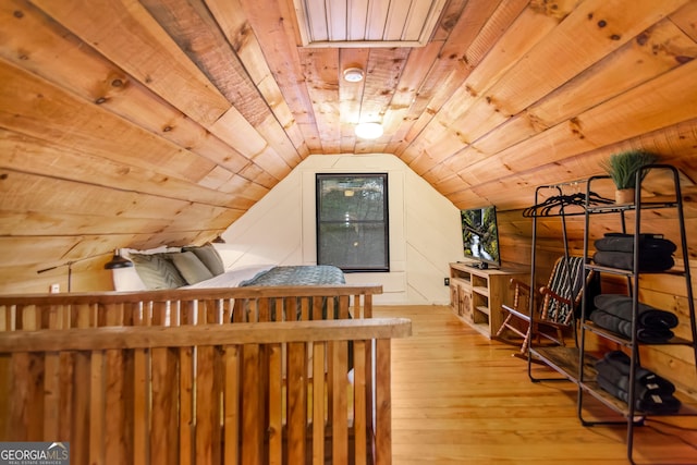 bedroom with vaulted ceiling, wooden ceiling, and light hardwood / wood-style floors