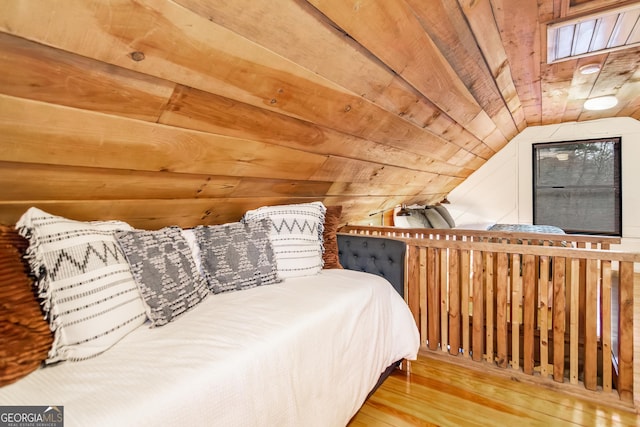 bedroom with wood walls, vaulted ceiling, wood-type flooring, and wood ceiling