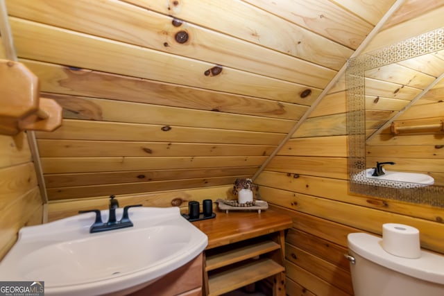 bathroom with sink, wood ceiling, toilet, and wooden walls