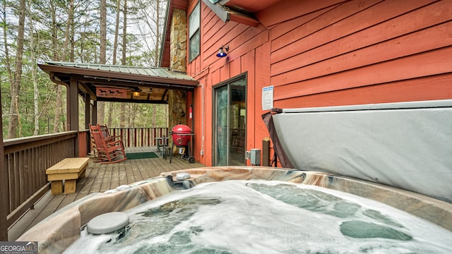 deck with grilling area and a hot tub