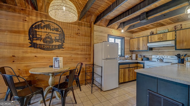 kitchen featuring white appliances, beamed ceiling, wooden walls, and wood ceiling