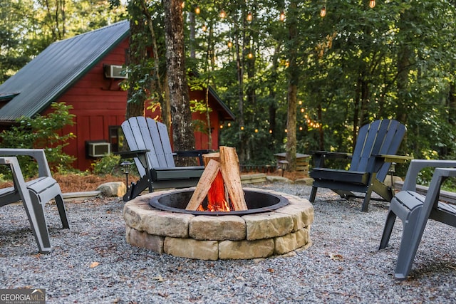 view of patio featuring an AC wall unit and a fire pit