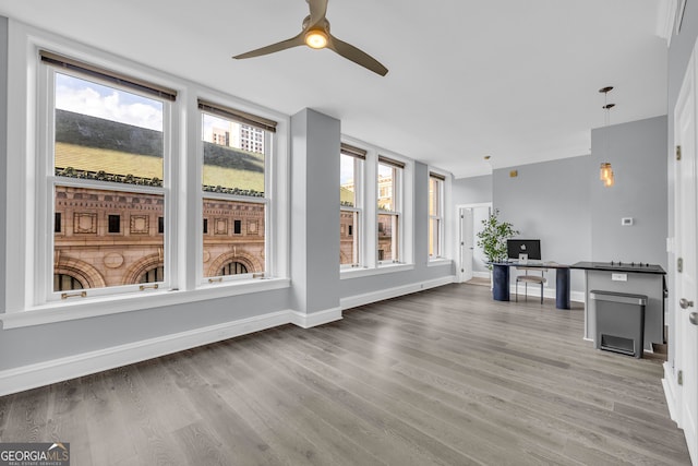 unfurnished sunroom with ceiling fan