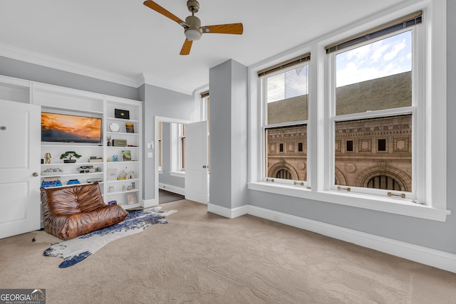 sitting room with light carpet, ornamental molding, and ceiling fan