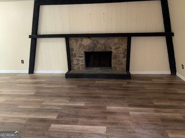 interior details featuring hardwood / wood-style flooring and a stone fireplace