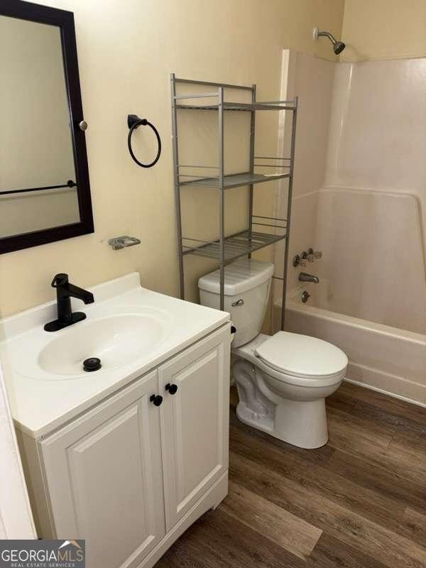 full bathroom with toilet, vanity, bathtub / shower combination, and hardwood / wood-style floors