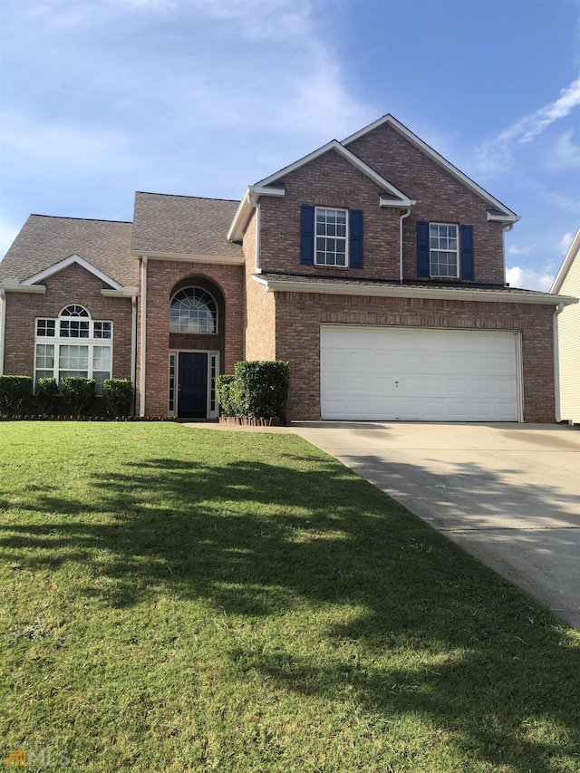 view of front of property with a garage and a front lawn