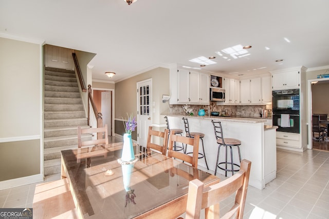 tiled dining room featuring crown molding