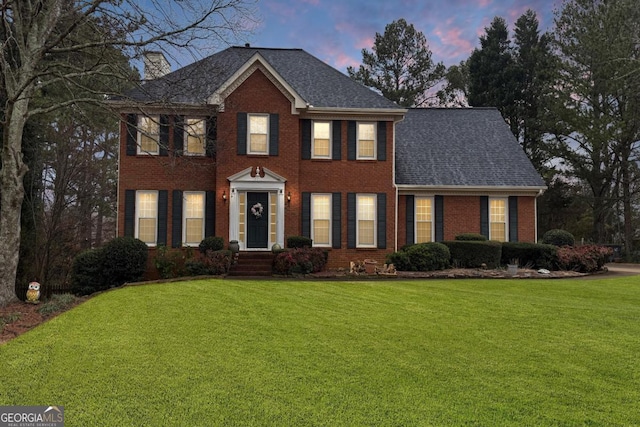 colonial home featuring a lawn