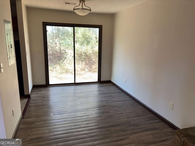 interior space with dark wood-type flooring, a healthy amount of sunlight, and a textured ceiling