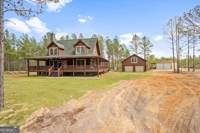 back of house with an outbuilding, a garage, a yard, and covered porch