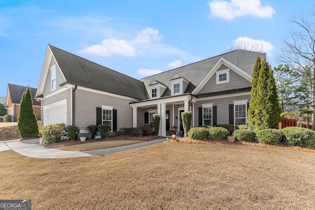 view of front of property with a front lawn, a porch, and roof with shingles