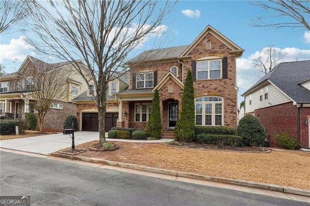 traditional-style house featuring a garage, concrete driveway, and brick siding