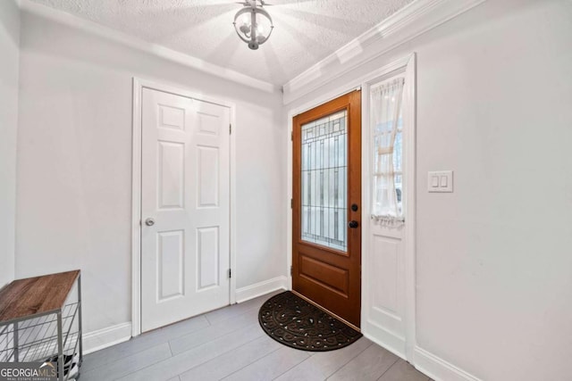 entrance foyer featuring a textured ceiling, wood finished floors, and baseboards