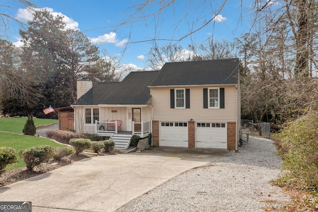 split level home with a garage, concrete driveway, a chimney, roof with shingles, and brick siding