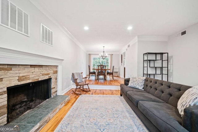 living room with light wood-style flooring, visible vents, and a fireplace with raised hearth