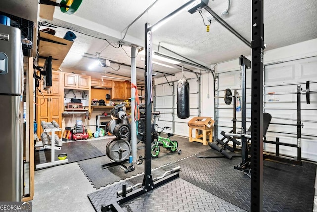 workout area featuring a garage and a textured ceiling