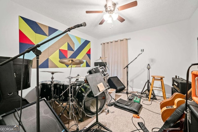 workout area with ceiling fan, baseboards, and a textured ceiling