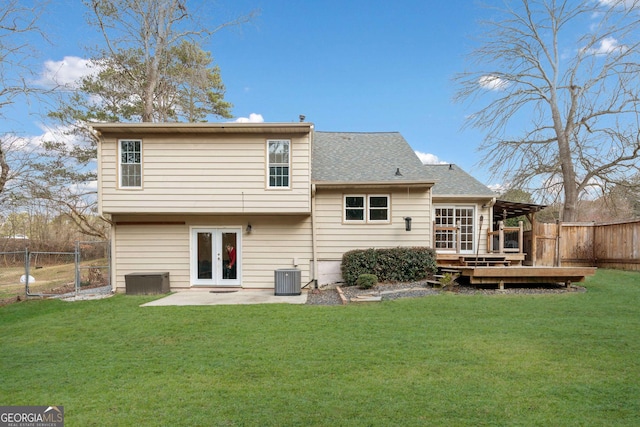 back of house with a lawn, french doors, a fenced backyard, a wooden deck, and central air condition unit