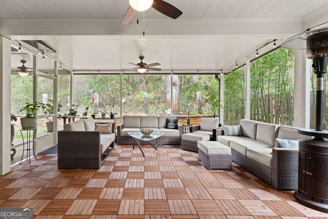 sunroom / solarium with track lighting, an outdoor living space, and ceiling fan
